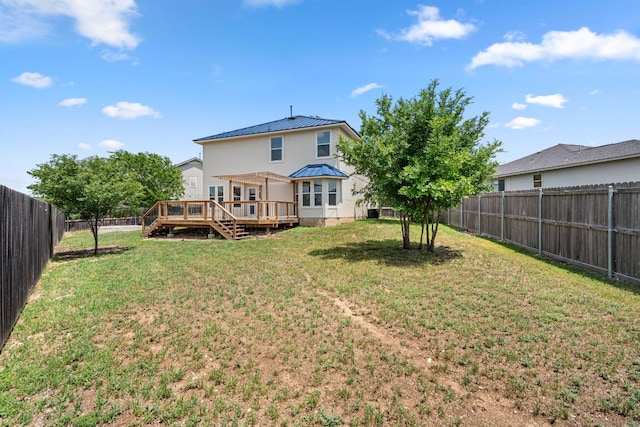 back of house featuring a fenced backyard, a wooden deck, a yard, and metal roof