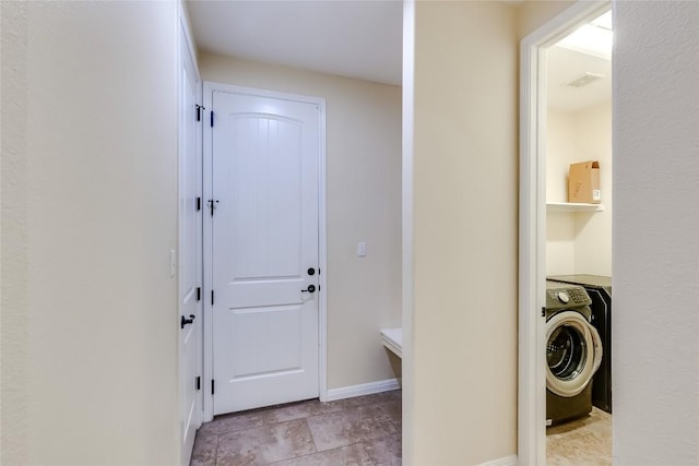 laundry room with visible vents, washer / dryer, baseboards, and stone finish floor