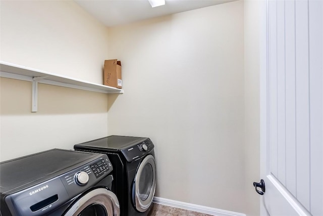 clothes washing area with laundry area, baseboards, and washer and dryer