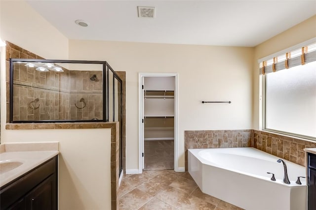 full bath with a shower stall, a bath, and vanity