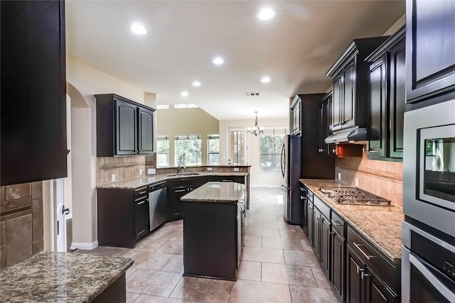 kitchen featuring backsplash, a sink, a peninsula, stainless steel appliances, and recessed lighting