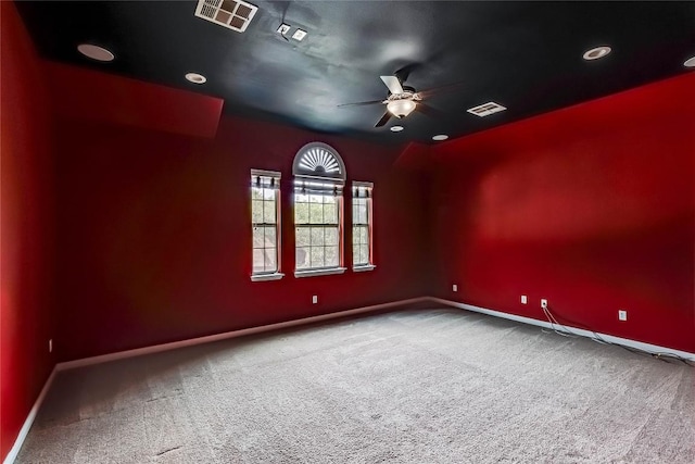 carpeted empty room with baseboards, ceiling fan, and visible vents