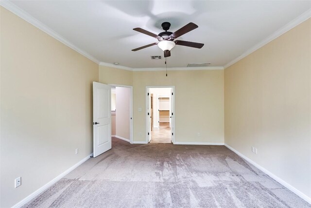 spare room with crown molding, ceiling fan, carpet, and visible vents