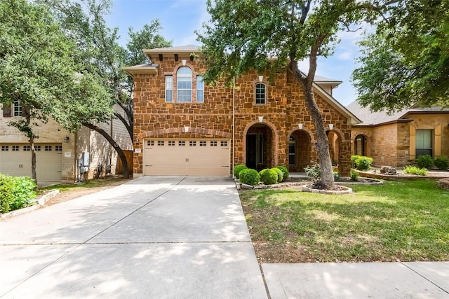 view of front of property featuring a garage, driveway, a front lawn, and stone siding