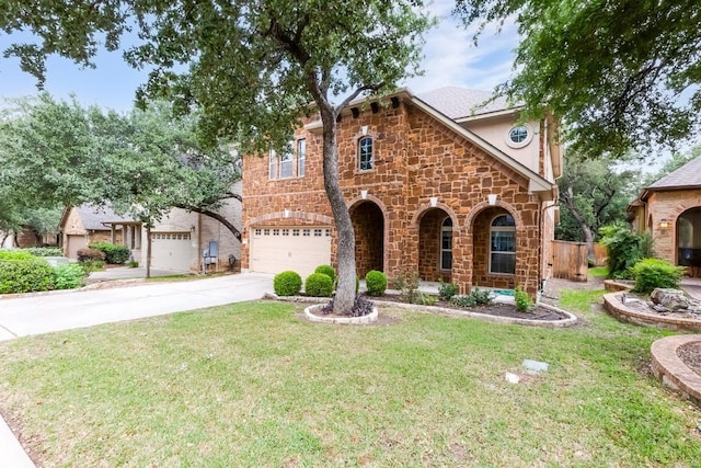 tudor house featuring an attached garage, a front lawn, stone siding, and concrete driveway