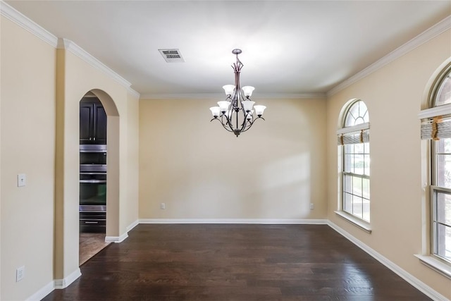 unfurnished dining area with arched walkways, a notable chandelier, wood finished floors, and a wealth of natural light