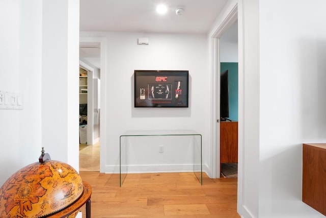 corridor featuring light wood-style floors and baseboards