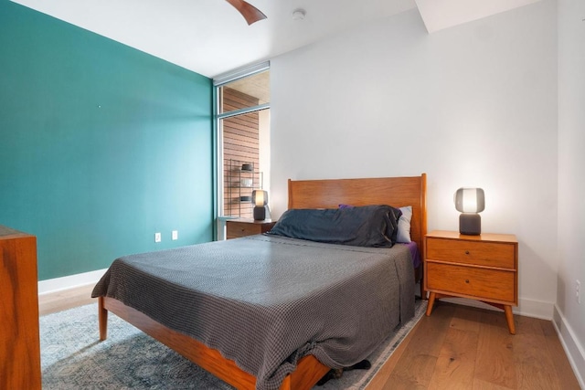bedroom featuring baseboards, a ceiling fan, and wood finished floors