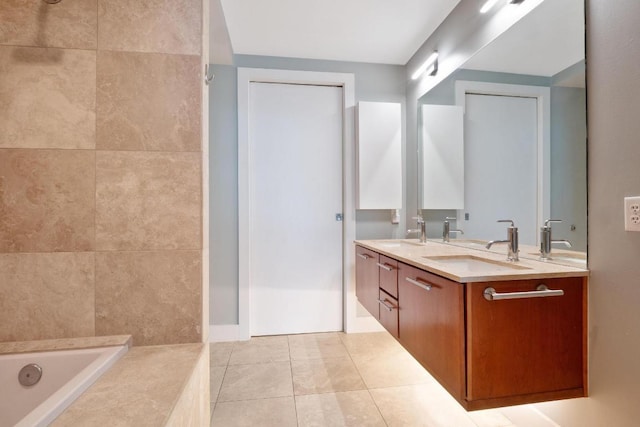 full bath with double vanity, tile patterned floors, a sink, and a garden tub