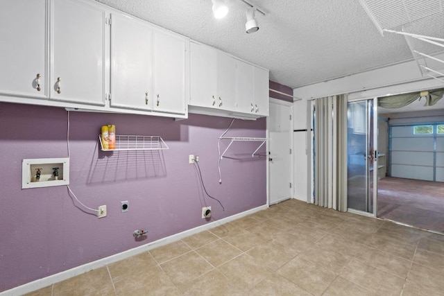 clothes washing area with cabinet space, hookup for a washing machine, gas dryer hookup, electric dryer hookup, and baseboards