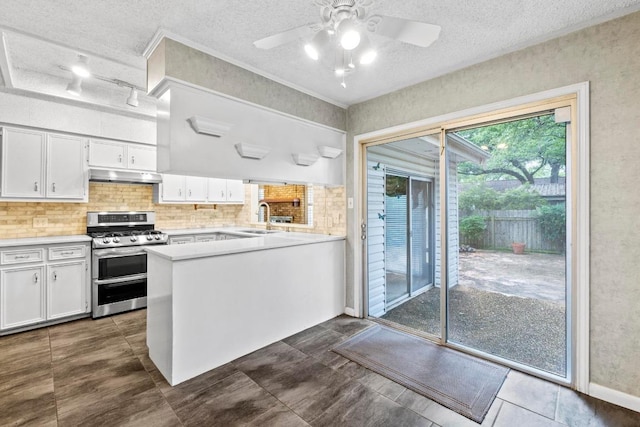 kitchen featuring under cabinet range hood, range with two ovens, white cabinets, and a sink