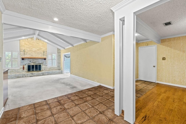 unfurnished living room with carpet flooring, lofted ceiling with beams, a brick fireplace, a textured ceiling, and visible vents