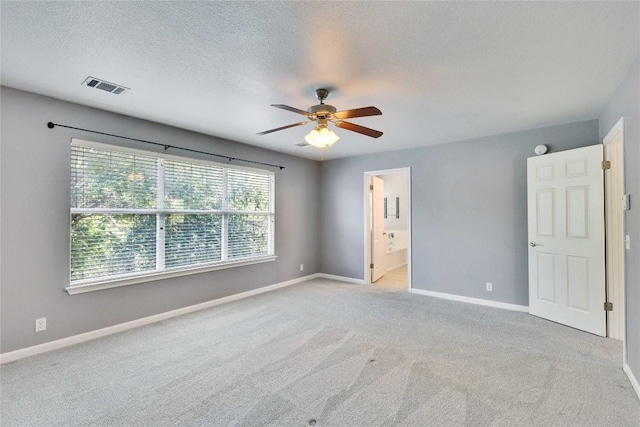 3957 Canyon Glen Cir, Austin, TX 78732 - unfurnished bedroom with light colored carpet, a textured ceiling, ensuite bathroom, and ceiling fan