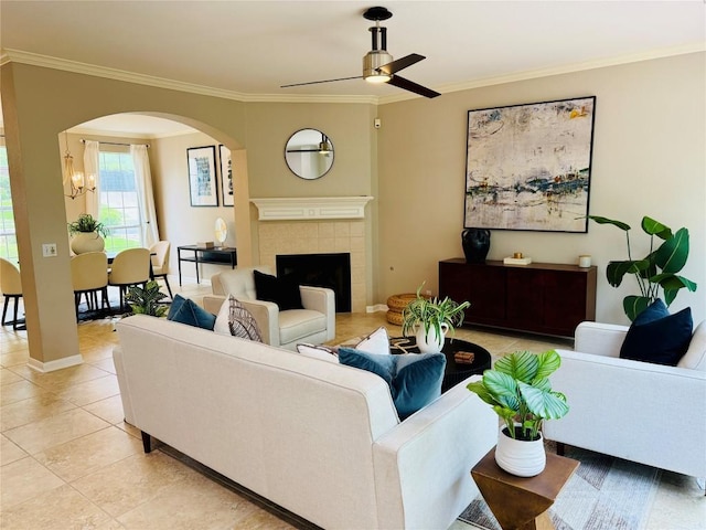 3957 Canyon Glen Cir, Austin, TX 78732 - living room featuring arched walkways, crown molding, a ceiling fan, light tile patterned flooring, and a tiled fireplace