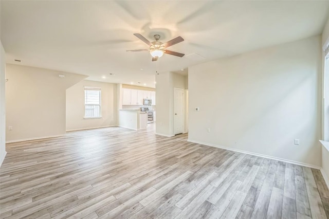 10401 American Paint Way, Manor, TX 78653 - unfurnished living room featuring ceiling fan, light wood-style floors, and baseboards