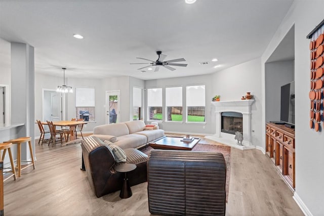 3912 Walsh Ranch Blvd, Round Rock, TX 78681 - living area featuring a fireplace with raised hearth, light wood-style flooring, a ceiling fan, and recessed lighting
