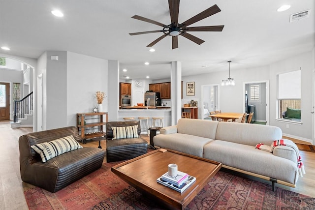 3912 Walsh Ranch Blvd, Round Rock, TX 78681 - living area with light wood-style floors, a ceiling fan, recessed lighting, arched walkways, and stairs