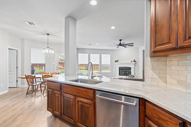 3912 Walsh Ranch Blvd, Round Rock, TX 78681 - kitchen with stainless steel dishwasher, tasteful backsplash, light stone counters, light wood-style floors, and ceiling fan