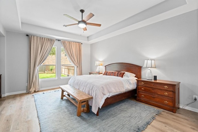 3912 Walsh Ranch Blvd, Round Rock, TX 78681 - bedroom featuring a raised ceiling, light wood-type flooring, and a ceiling fan