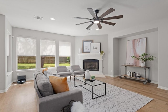 3912 Walsh Ranch Blvd, Round Rock, TX 78681 - living room with light wood-style flooring, ceiling fan, a tiled fireplace, and recessed lighting