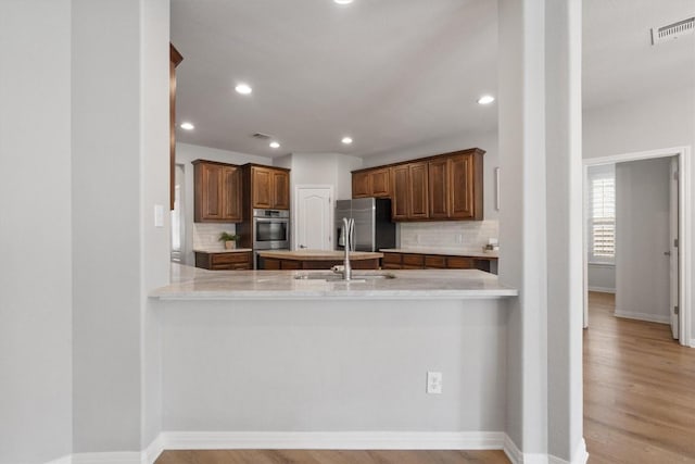 3912 Walsh Ranch Blvd, Round Rock, TX 78681 - kitchen with stainless steel appliances, a peninsula, decorative backsplash, recessed lighting, and light countertops
