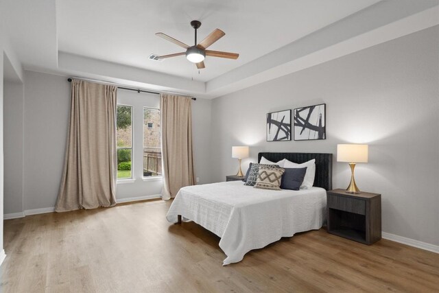 3912 Walsh Ranch Blvd, Round Rock, TX 78681 - bedroom with a raised ceiling, wood finished floors, and ceiling fan