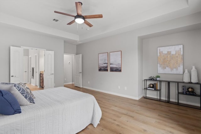 3912 Walsh Ranch Blvd, Round Rock, TX 78681 - bedroom with a raised ceiling, light wood finished floors, and a ceiling fan