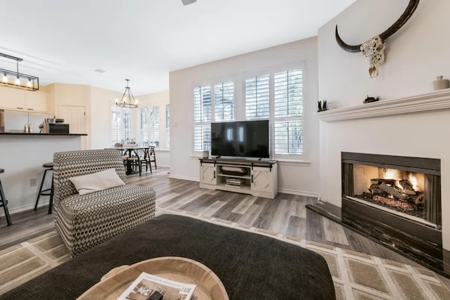 12407 Old Salt Trl, Austin, TX 78732 - living room with a wealth of natural light, wood finished floors, a chandelier, and a lit fireplace