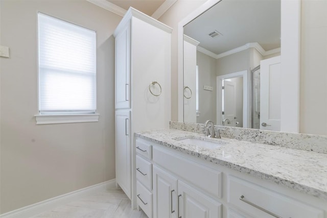 bathroom featuring crown molding, vanity, plenty of natural light, and baseboards