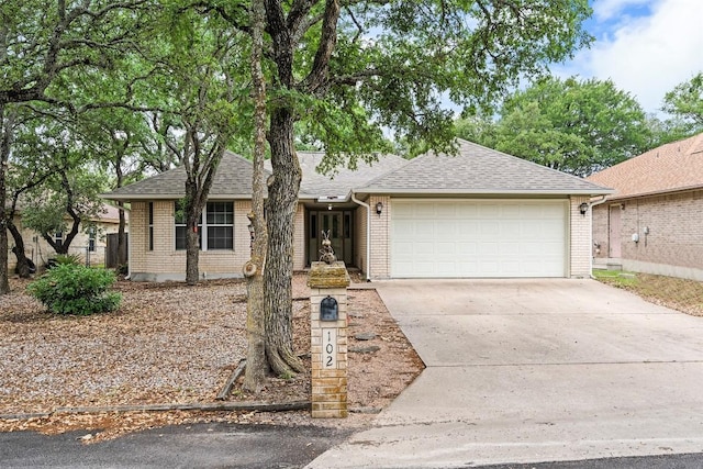 102 Vandeventer Dr, Burnet, TX 78611 - single story home with brick siding, a garage, concrete driveway, and a shingled roof