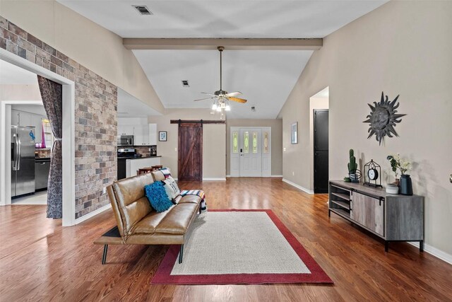 102 Vandeventer Dr, Burnet, TX 78611 - living room featuring a barn door, light wood-style flooring, ceiling fan, beamed ceiling, and baseboards