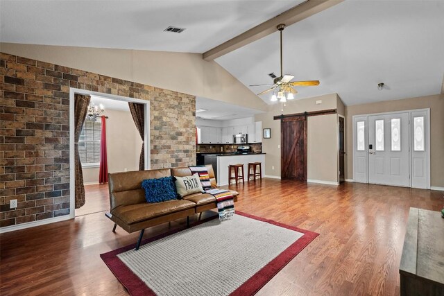 102 Vandeventer Dr, Burnet, TX 78611 - living room featuring a barn door, wood finished floors, a ceiling fan, beamed ceiling, and baseboards