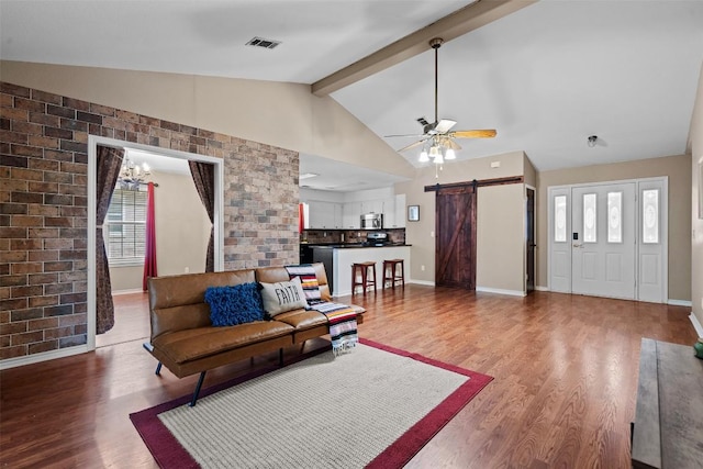 102 Vandeventer Dr, Burnet, TX 78611 - living room featuring a barn door, wood finished floors, beamed ceiling, a ceiling fan, and baseboards