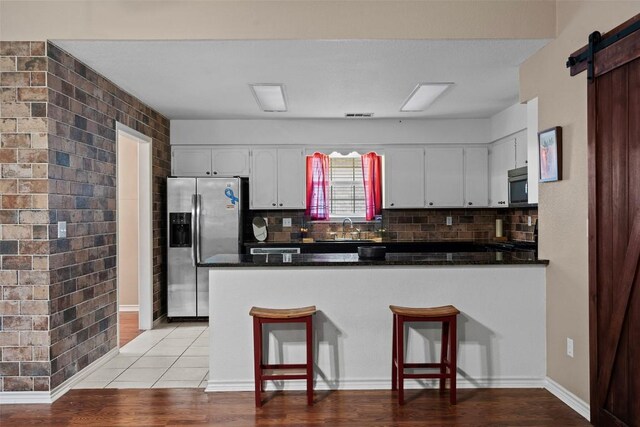 102 Vandeventer Dr, Burnet, TX 78611 - kitchen featuring stainless steel appliances, a sink, dark countertops, a peninsula, and white cabinetry