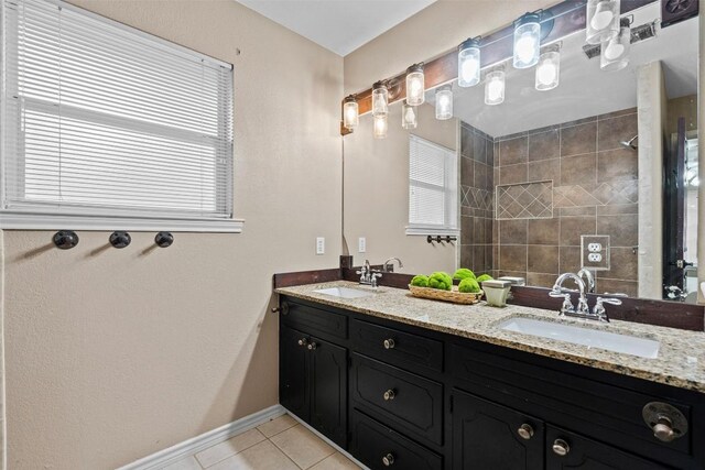 102 Vandeventer Dr, Burnet, TX 78611 - bathroom featuring double vanity, tile patterned flooring, a tile shower, and baseboards