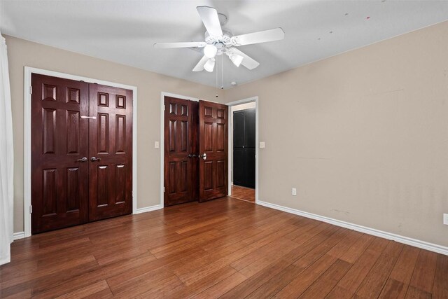102 Vandeventer Dr, Burnet, TX 78611 - unfurnished bedroom with wood finished floors, baseboards, and ceiling fan