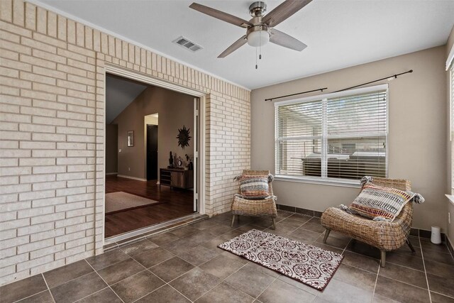 102 Vandeventer Dr, Burnet, TX 78611 - living area with a ceiling fan, tile patterned floors, brick wall, and baseboards