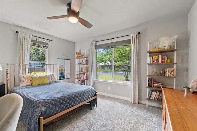 carpeted bedroom featuring baseboards and ceiling fan