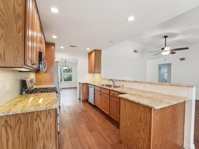 11911 Aloe Vera Trl, Austin, TX 78750 - kitchen featuring stainless steel appliances, a peninsula, light wood-style flooring, brown cabinets, and recessed lighting