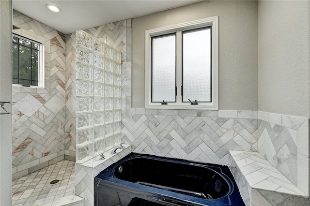 bathroom featuring tiled shower, recessed lighting, and a bath