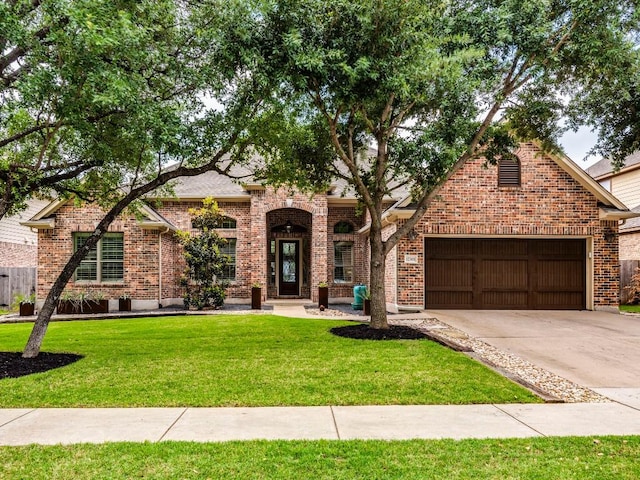 view of front facade with brick siding, driveway, a front yard, and a garage