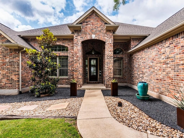property entrance with brick siding and roof with shingles