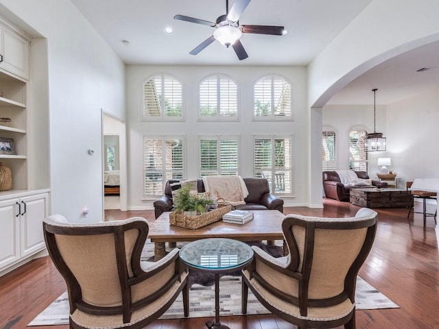interior space with a ceiling fan, dark wood-style flooring, a high ceiling, recessed lighting, and arched walkways