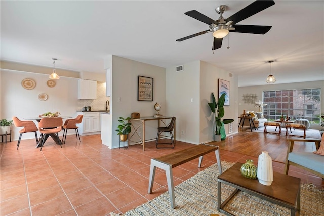 7253 Creekside Dr, Austin, TX 78752 - living area with light tile patterned floors, baseboards, ceiling fan, and visible vents