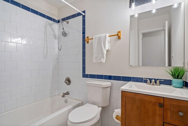 7253 Creekside Dr, Austin, TX 78752 - full bathroom featuring shower / bathtub combination, tile walls, toilet, a wainscoted wall, and vanity