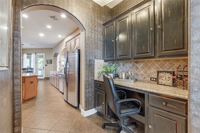 2607 Armatrading Dr, Cedar Park, TX 78613 - home office featuring light tile patterned floors, arched walkways, a sink, recessed lighting, and baseboards