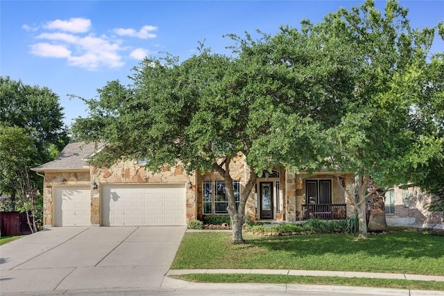 view of property hidden behind natural elements with an attached garage, a front lawn, stone siding, a porch, and driveway