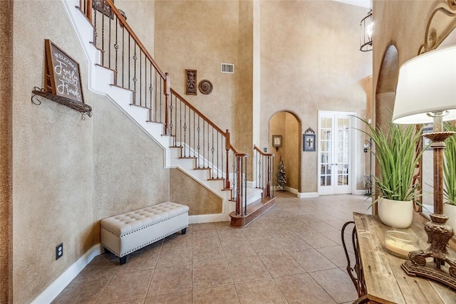 2607 Armatrading Dr, Cedar Park, TX 78613 - foyer featuring a towering ceiling, stairway, arched walkways, french doors, and tile patterned flooring