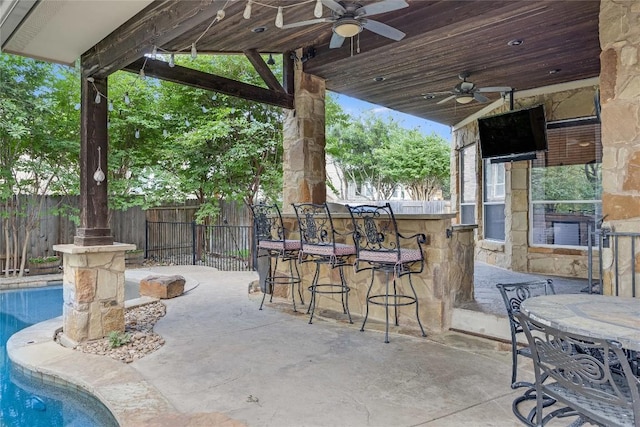 view of patio / terrace featuring a fenced in pool, a fenced backyard, a ceiling fan, and outdoor dry bar