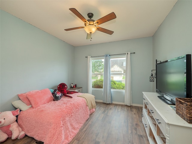 bedroom featuring baseboards, ceiling fan, and light wood-type flooring